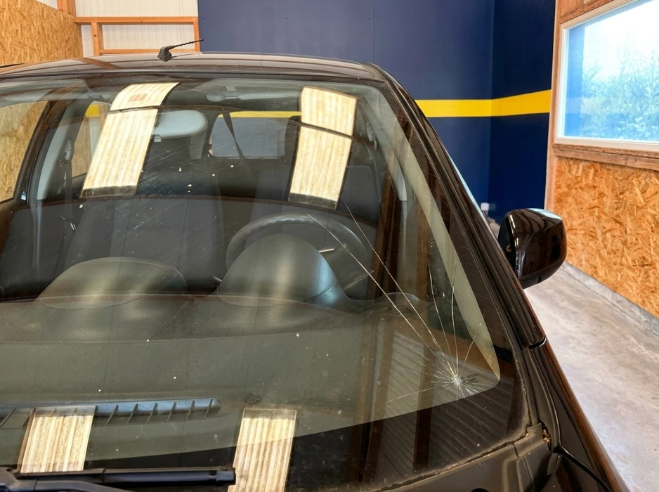 Véhicule noir garé dans un atelier de carrosserie