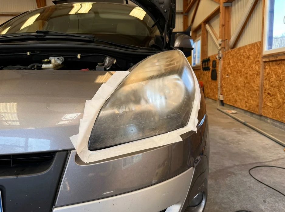 Garage intérieur, capot ouvert d'une berline grise