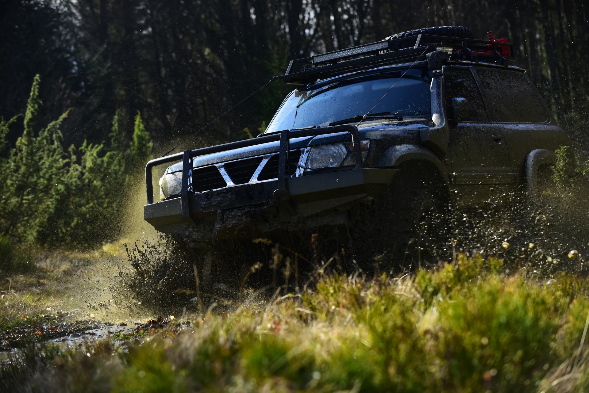 Véhicule SUV blanc stationné sur terrain rocheux montagneux au coucher du soleil